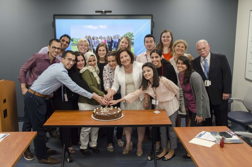 Group of students huddled around a cake