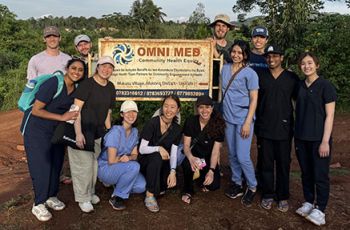GW medical students standing in front of a Omni Med sign in Makata Village, Uganda