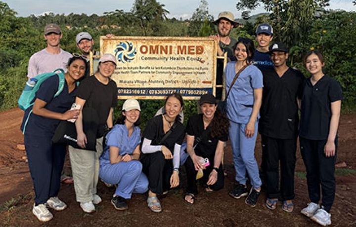 GW medical students standing in front of a Omni Med sign in Makata Village, Uganda